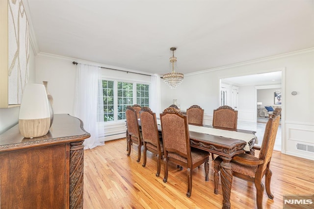 dining space featuring a baseboard radiator, ornamental molding, light hardwood / wood-style floors, and an inviting chandelier