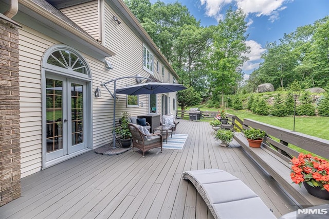 deck with outdoor lounge area, a grill, and french doors