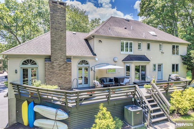 rear view of house with french doors and a wooden deck