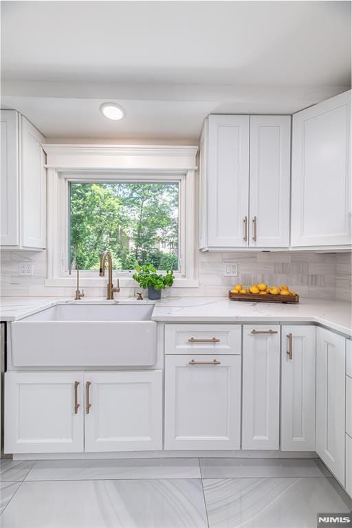 kitchen with sink, white cabinetry, and decorative backsplash