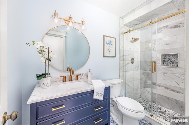 bathroom with vanity, a shower with shower door, and toilet