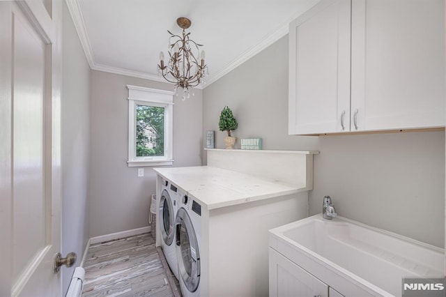 laundry area with light hardwood / wood-style flooring, washing machine and dryer, cabinets, ornamental molding, and an inviting chandelier