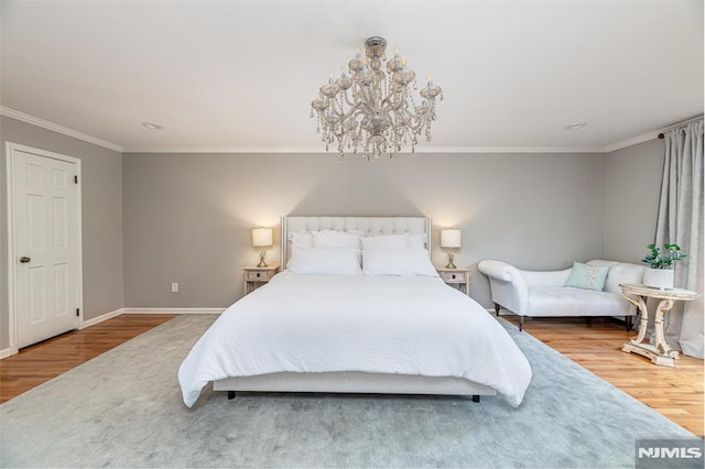 bedroom with hardwood / wood-style floors, crown molding, and a chandelier