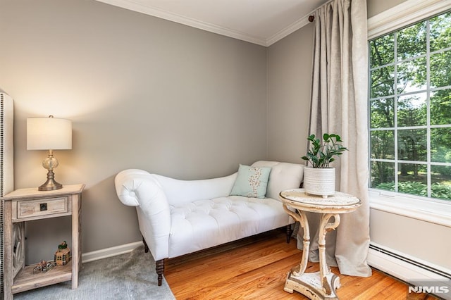 living area with wood-type flooring, baseboard heating, and ornamental molding