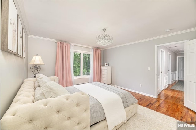 bedroom with wood-type flooring, ornamental molding, and a chandelier