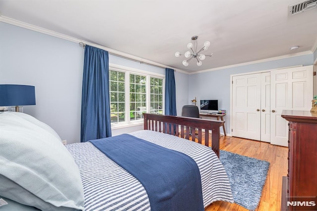 bedroom featuring an inviting chandelier, light hardwood / wood-style flooring, a closet, and ornamental molding