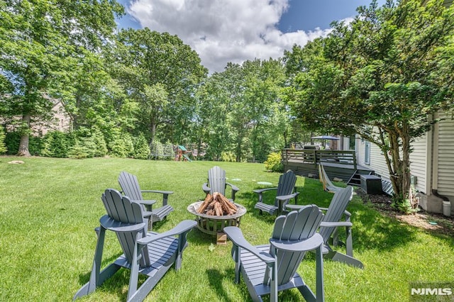 view of yard with an outdoor fire pit and a playground