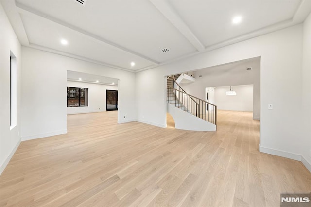 unfurnished living room with beam ceiling and light hardwood / wood-style flooring