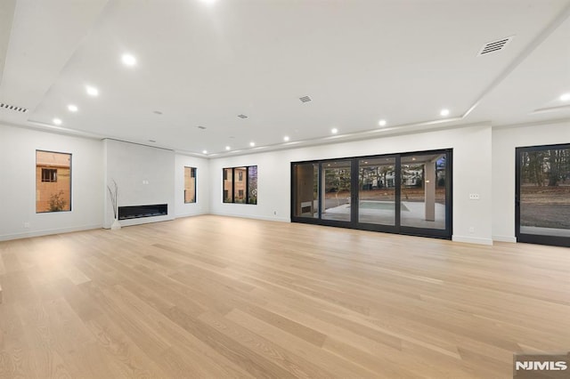 unfurnished living room with light hardwood / wood-style flooring, a fireplace, and plenty of natural light