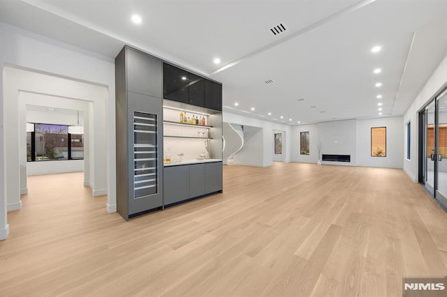 bar featuring a fireplace and light wood-type flooring