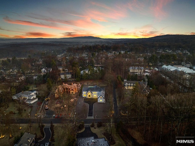 aerial view at dusk featuring a mountain view