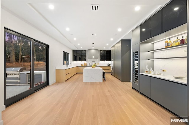 kitchen featuring a spacious island, sink, and light hardwood / wood-style floors