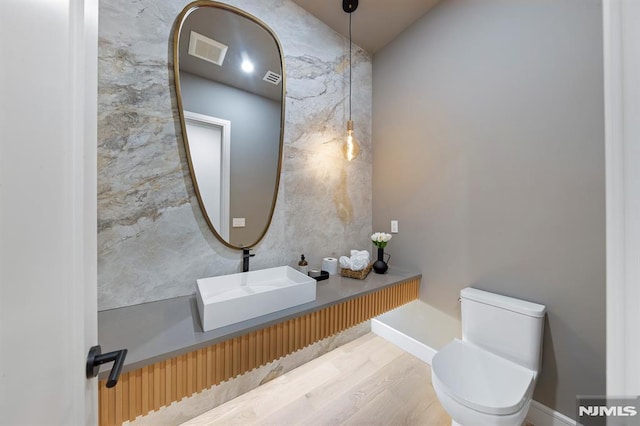 bathroom with sink, hardwood / wood-style floors, and toilet