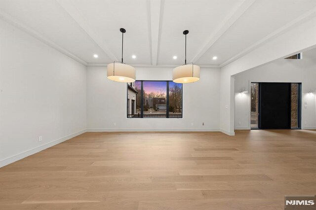 unfurnished dining area featuring beam ceiling and light hardwood / wood-style flooring