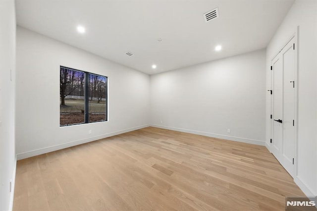 empty room with light hardwood / wood-style flooring