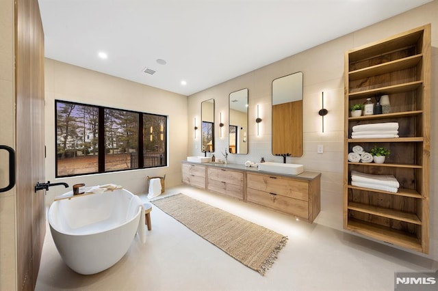 bathroom featuring vanity and a bath