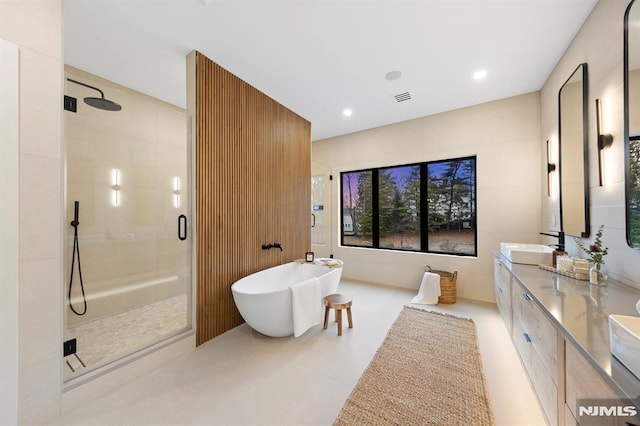 bathroom with vanity and independent shower and bath