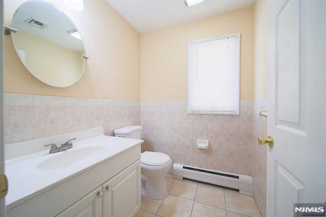 bathroom featuring toilet, tile walls, a baseboard radiator, tile patterned flooring, and vanity