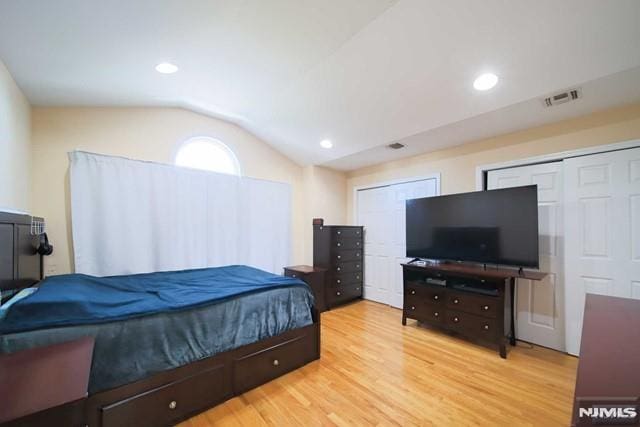 bedroom featuring light hardwood / wood-style floors and lofted ceiling