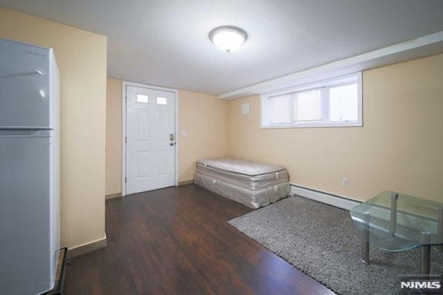 foyer with dark wood-type flooring and baseboard heating