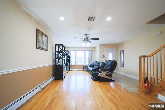 sitting room featuring ceiling fan, light hardwood / wood-style floors, and a baseboard heating unit