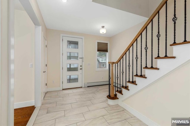 foyer entrance with a baseboard heating unit