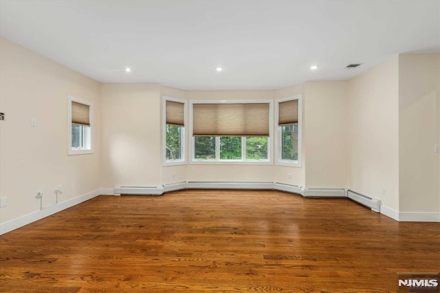 unfurnished room with hardwood / wood-style flooring and a baseboard radiator