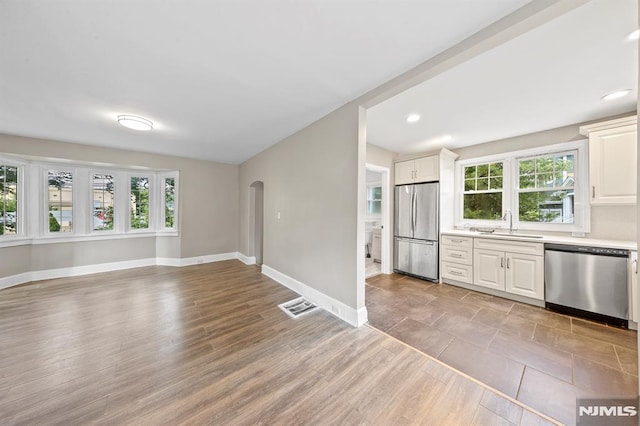 kitchen featuring sink, a healthy amount of sunlight, white cabinets, and stainless steel appliances