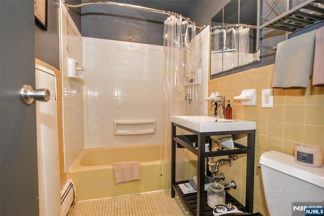 full bathroom with toilet, sink, tile walls, a baseboard radiator, and shower / bath combo with shower curtain