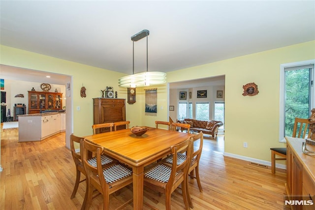 dining space with a healthy amount of sunlight and light hardwood / wood-style floors