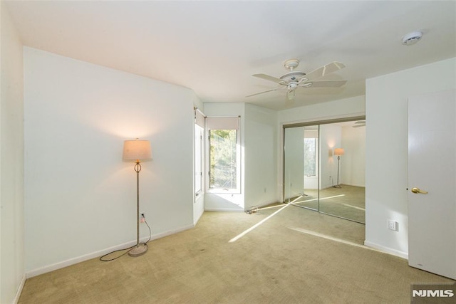 unfurnished bedroom with ceiling fan, a closet, and carpet flooring