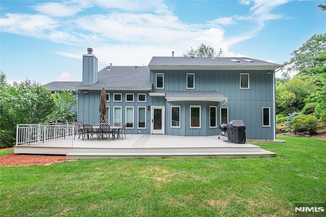 back of house with a wooden deck and a lawn