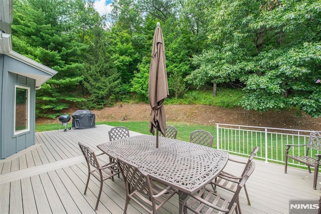 wooden deck with a lawn and grilling area