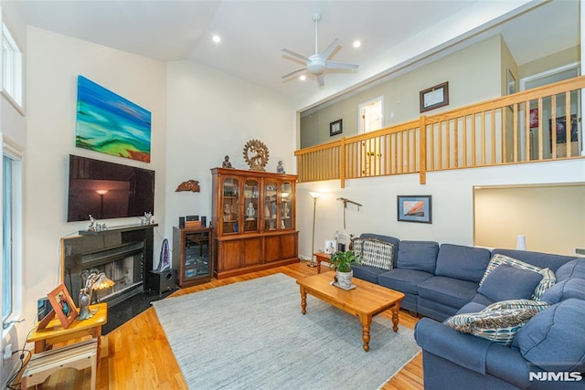 living room featuring high vaulted ceiling, hardwood / wood-style floors, ceiling fan, and a healthy amount of sunlight