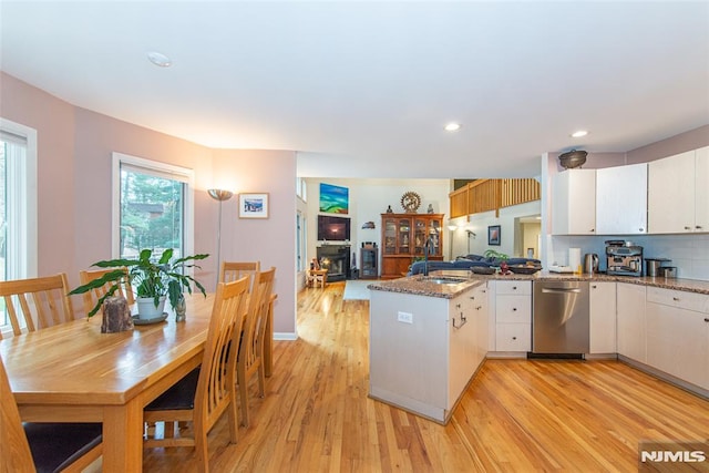 kitchen with white cabinets, dishwasher, kitchen peninsula, and sink