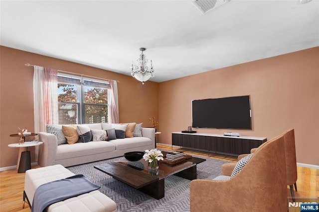 living room with a chandelier and light wood-type flooring