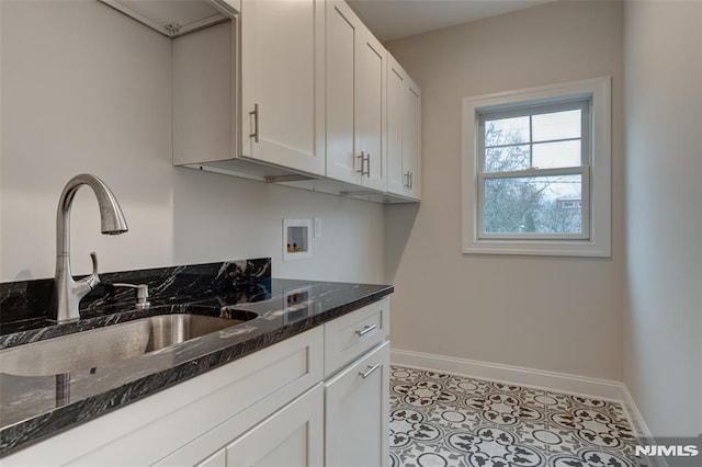 kitchen with sink, white cabinetry, and dark stone countertops