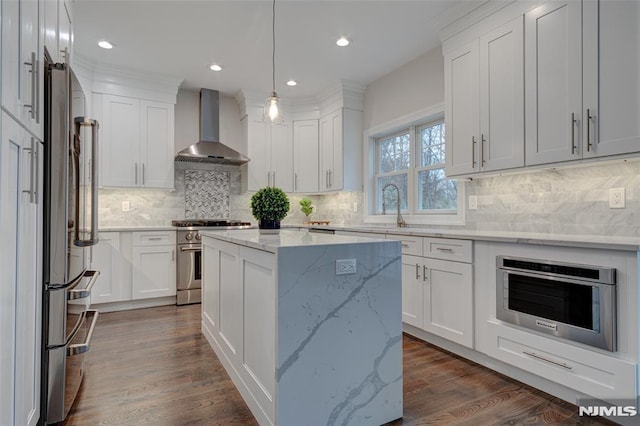 kitchen with white cabinets, stainless steel appliances, and wall chimney exhaust hood