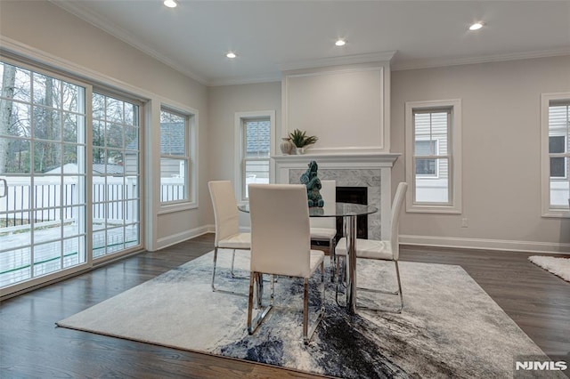 dining space with ornamental molding, dark hardwood / wood-style floors, and a fireplace