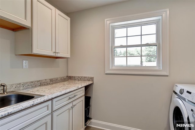 laundry area with sink, washer / clothes dryer, and cabinets