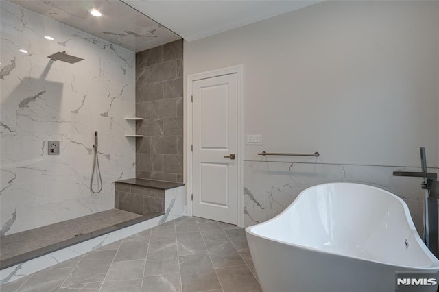 bathroom featuring shower with separate bathtub and tile walls