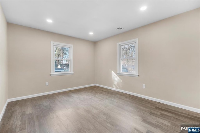 unfurnished room featuring hardwood / wood-style floors and a healthy amount of sunlight