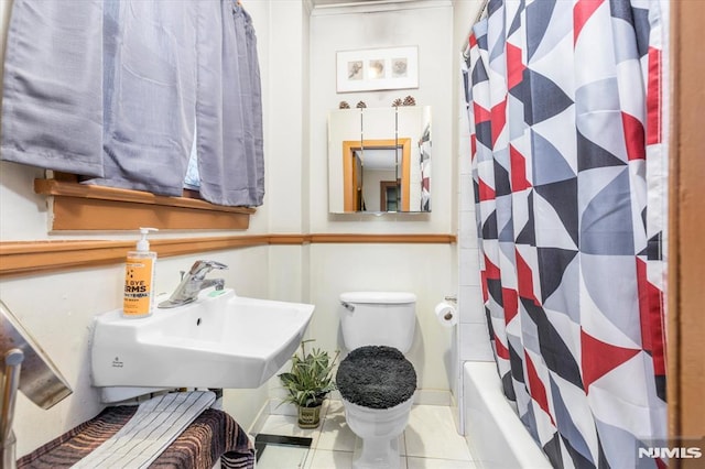 full bathroom featuring shower / bath combination with curtain, sink, toilet, and tile patterned flooring