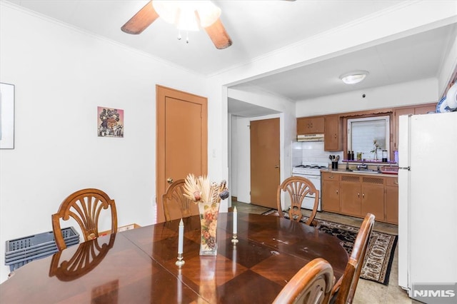 dining room featuring ornamental molding, sink, and ceiling fan