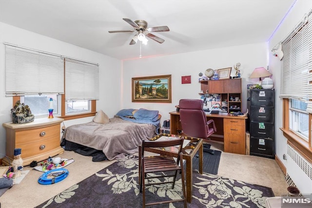 bedroom with carpet flooring, radiator, and ceiling fan