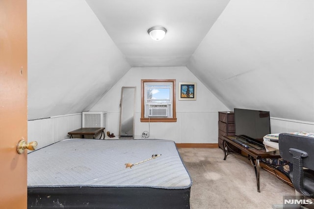 bedroom featuring cooling unit, lofted ceiling, and carpet flooring