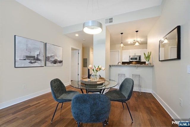 dining area with electric panel, visible vents, dark wood-type flooring, and baseboards