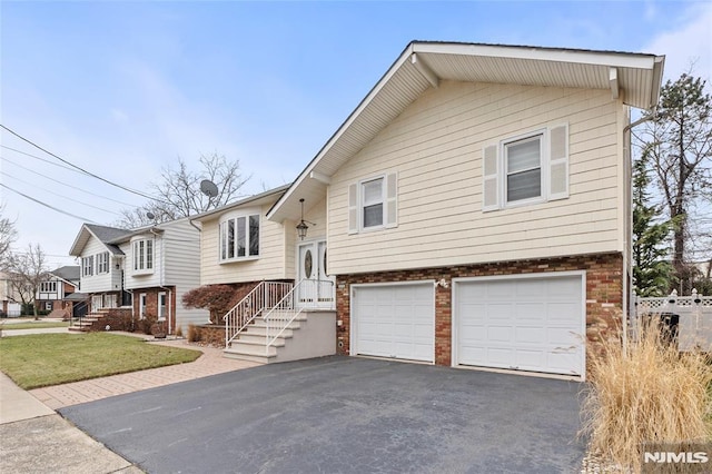 split foyer home with a garage and a front yard