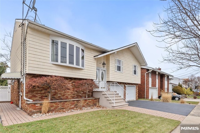 split foyer home featuring a garage and a front yard