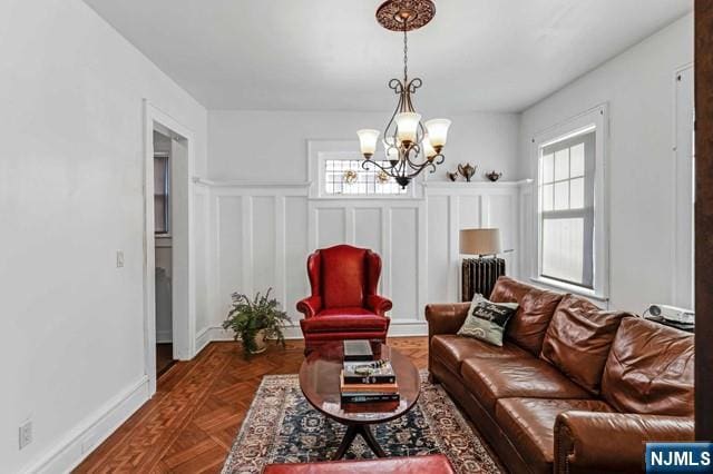 living room with dark parquet flooring, radiator heating unit, and a chandelier